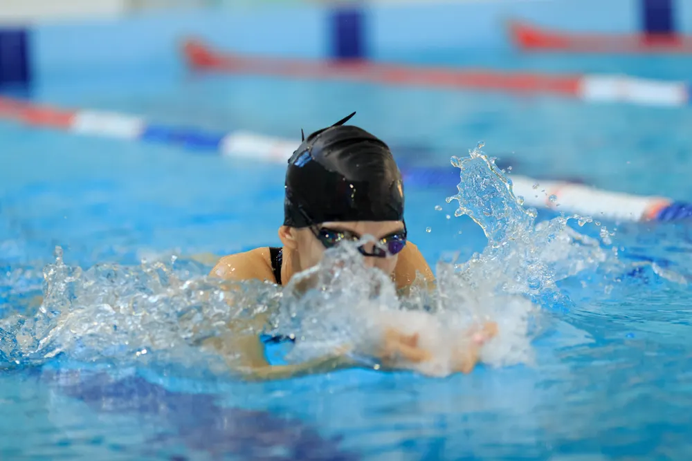 Young swimmer in cap and goggles during a pool training session